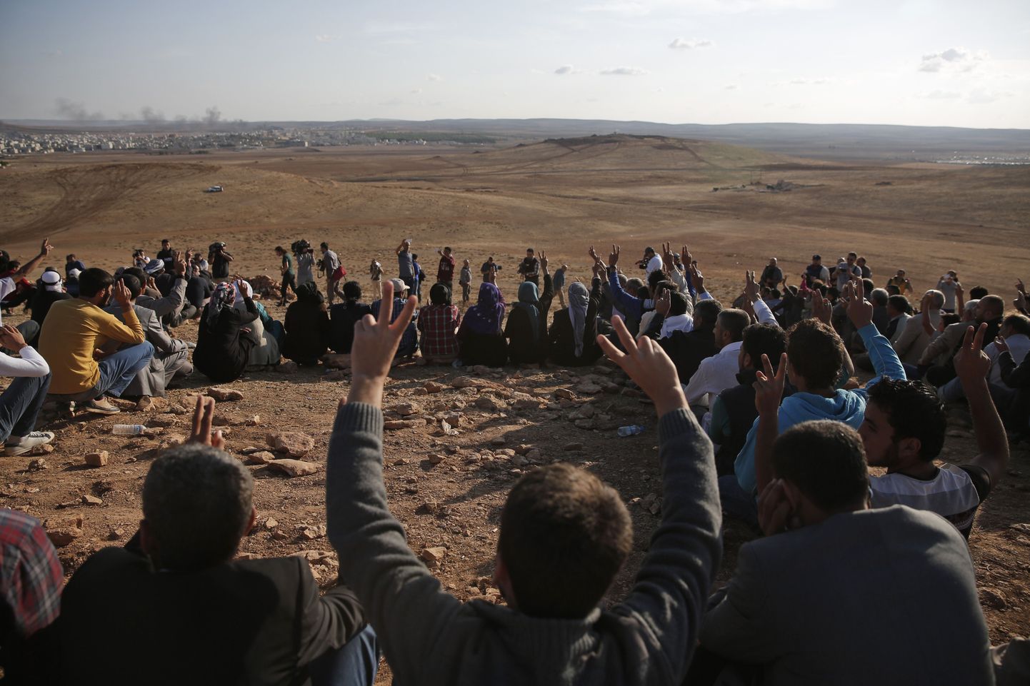 Türgi kurdid jälgivad piiri lähistel küngastel istudes pidevalt Kobanes toimuvaid õhulööke.
