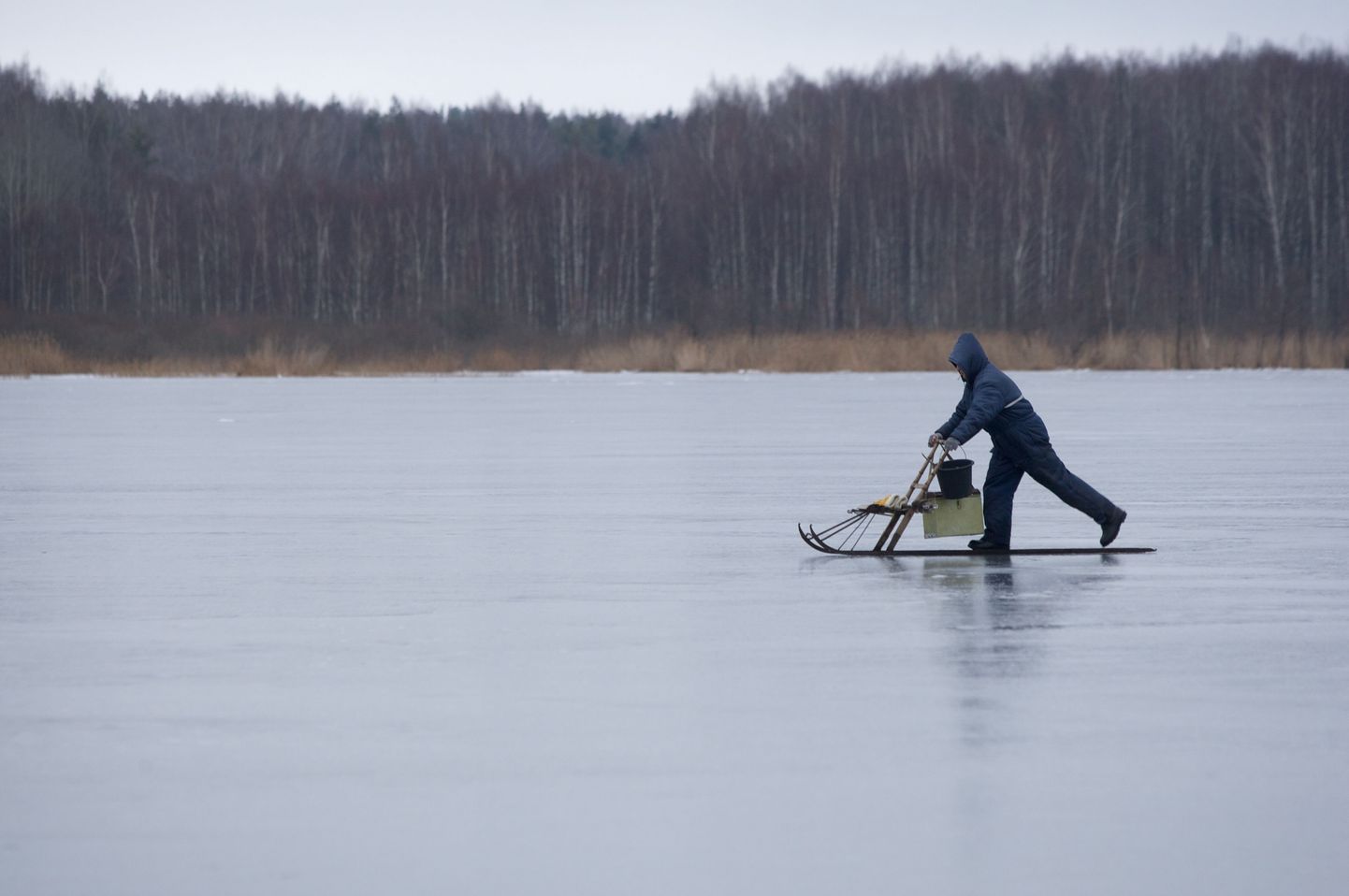 Рыбак на льду озера.
