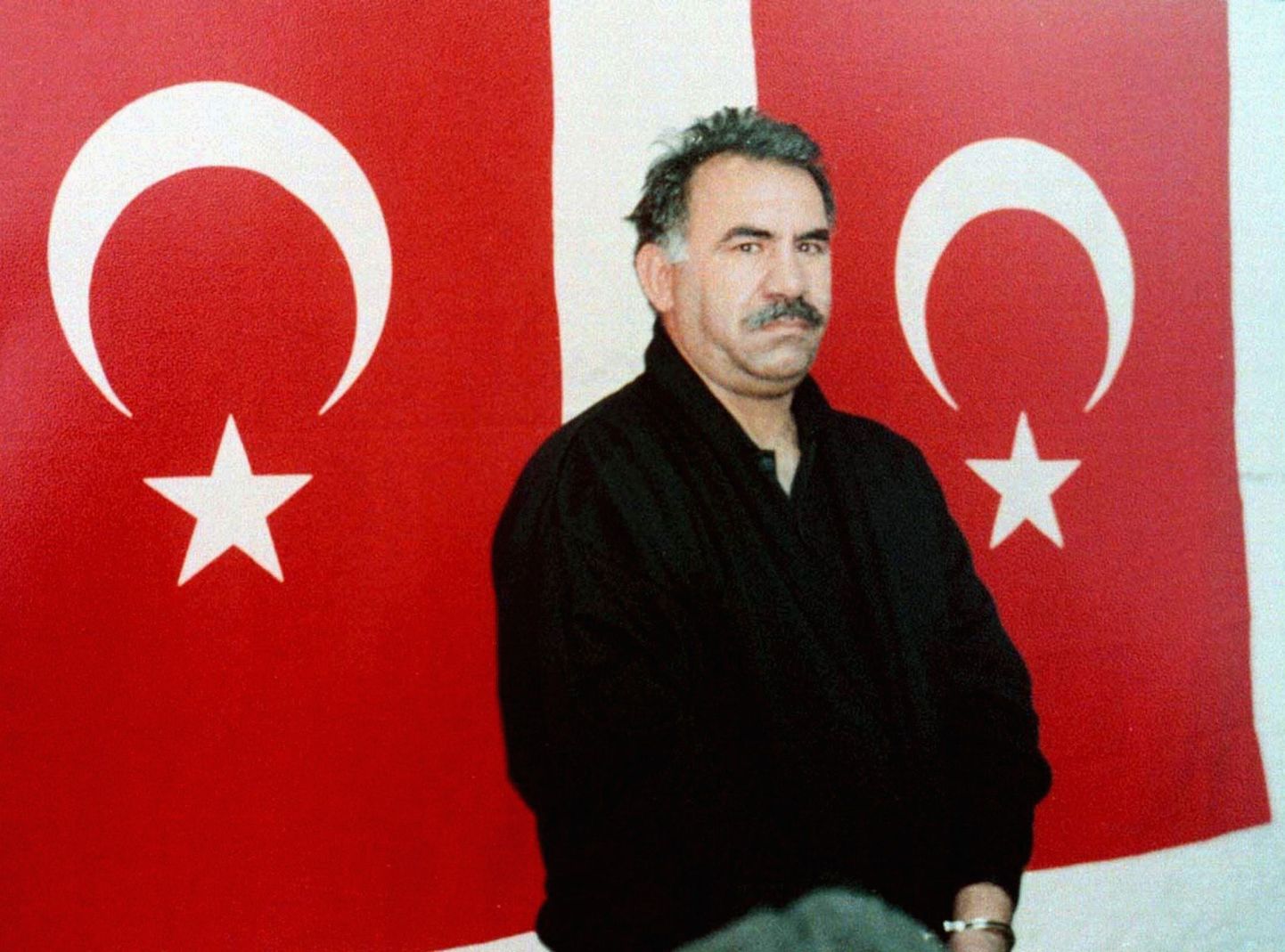 Türgi kurdide liider Abdullah Öcalan Imrali vanglasaarel asuvas kinnipidamisasutuses Türgi lippude ees poseerimas.