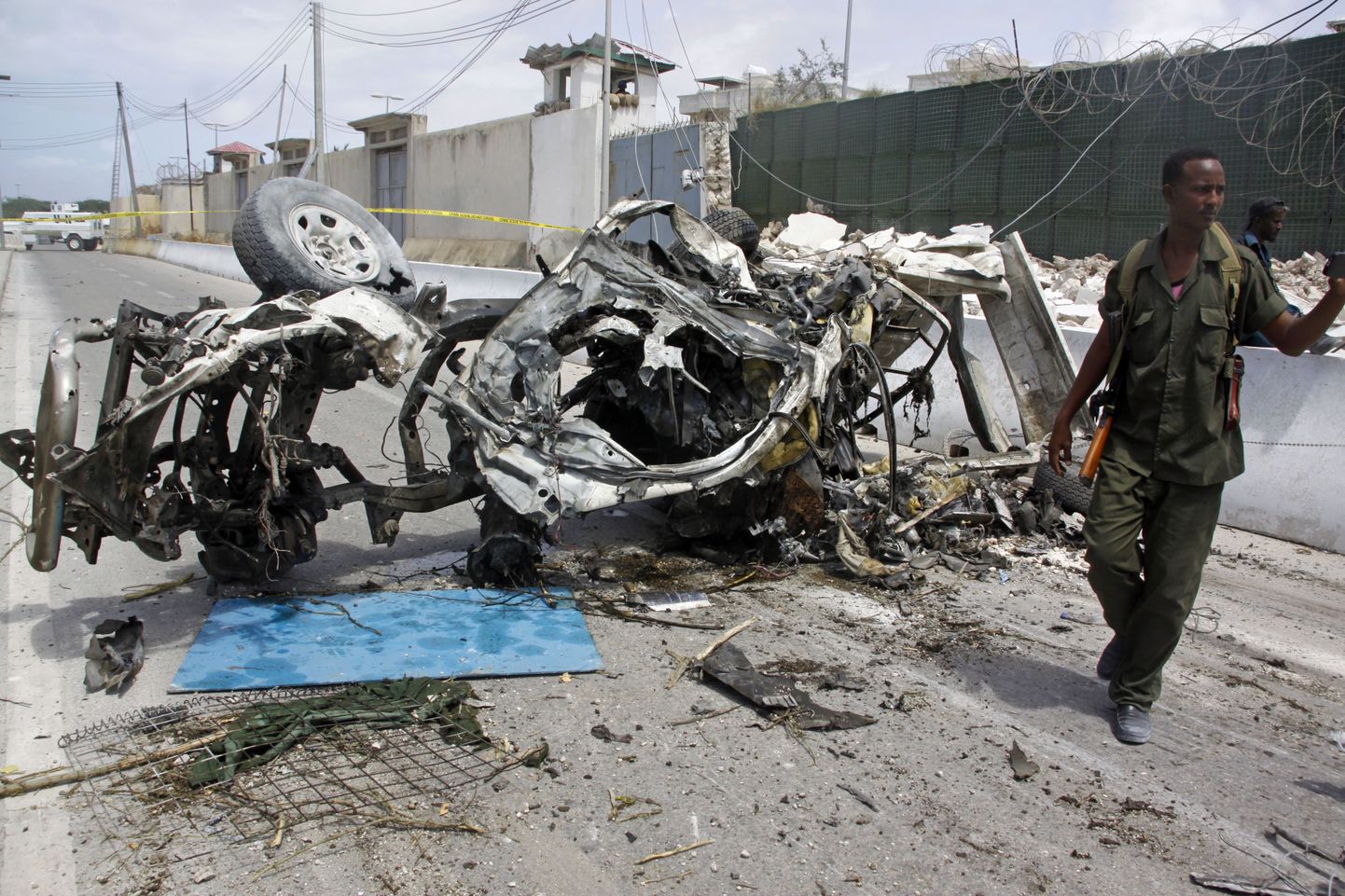 Somaali sõdur seismas Mogadishus plahvatanud auto juures.