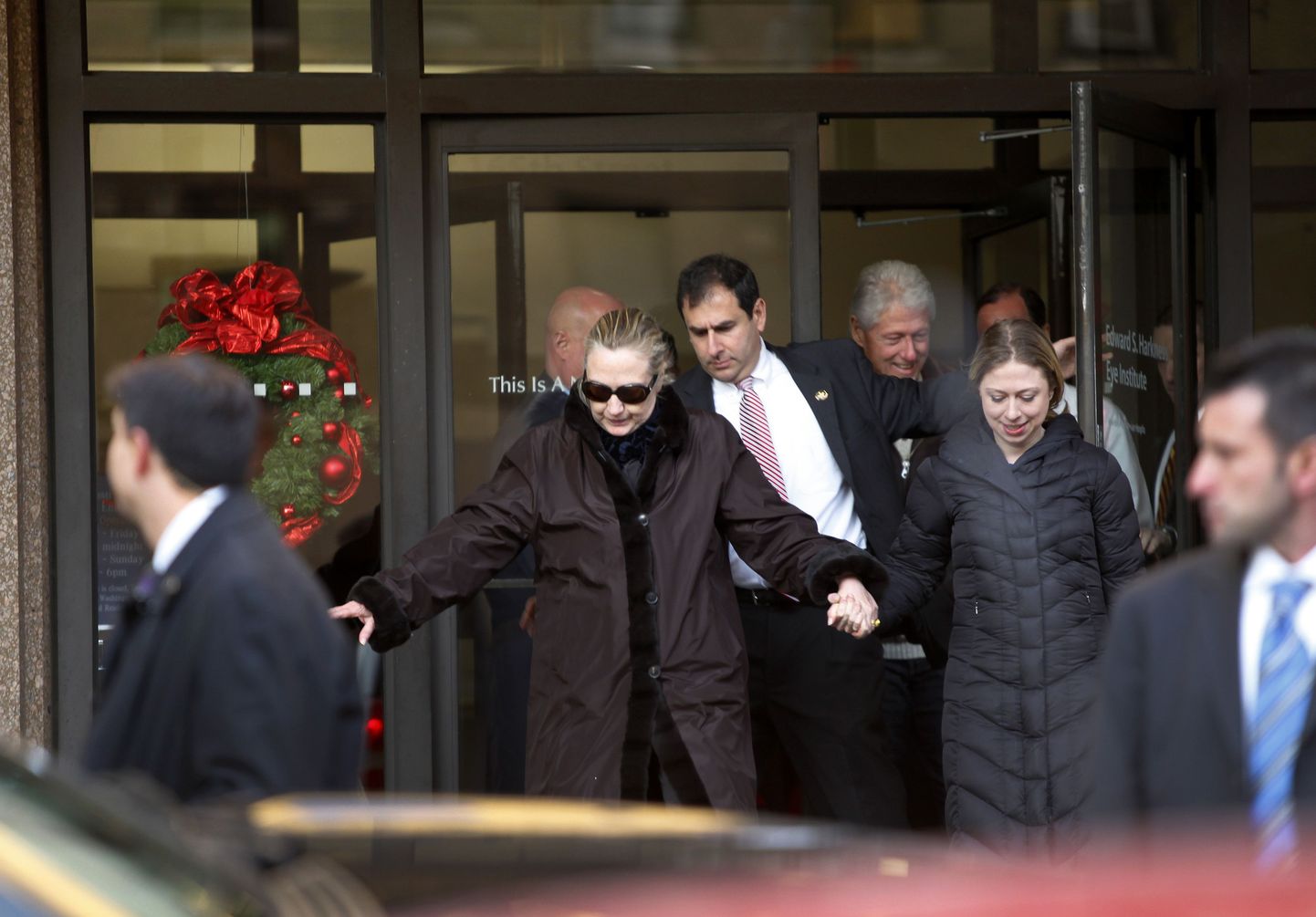 Hillary Clinton (keskel) koos tütre, mehe ja nõunikuga haiglast lahkumas