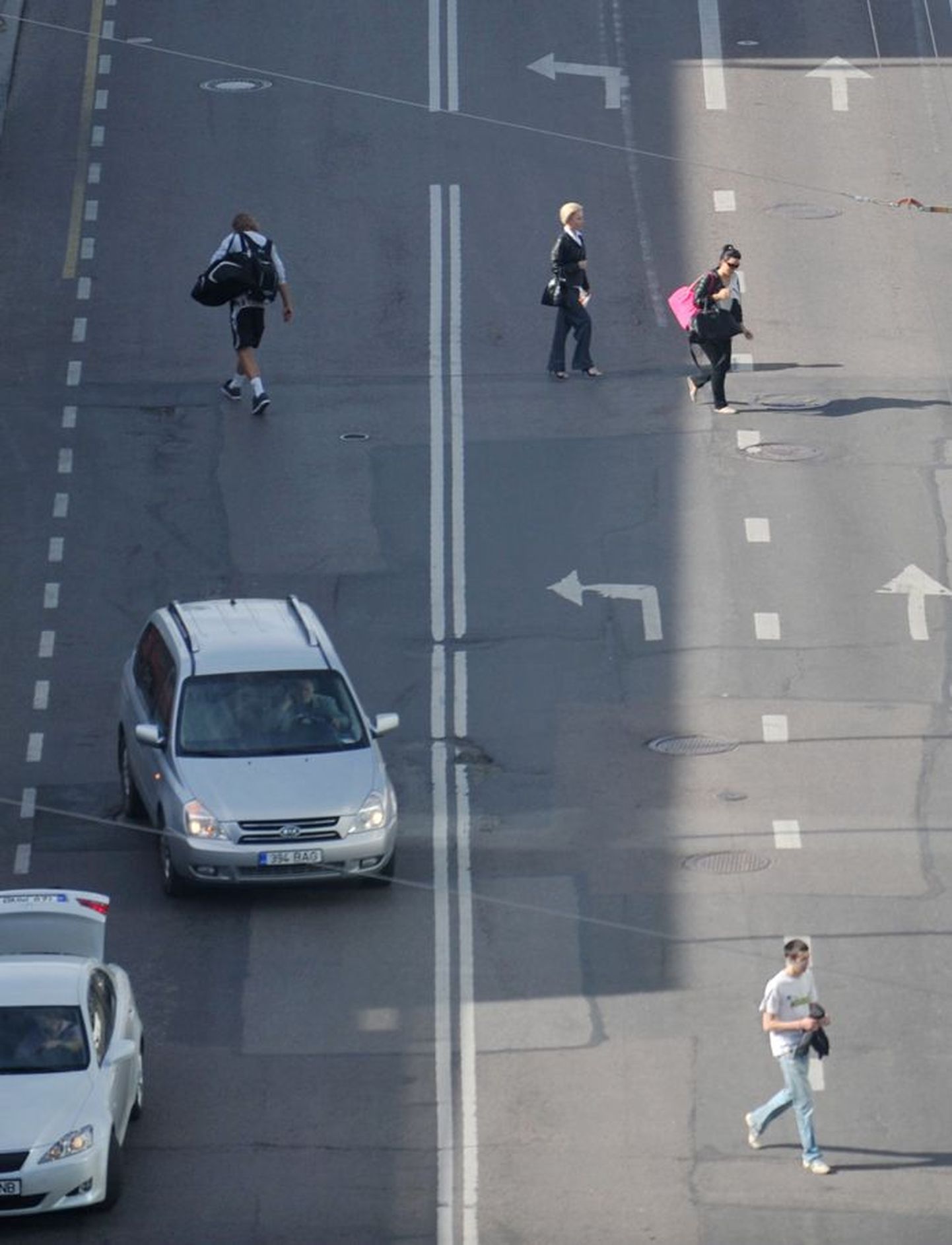 Пешеходы переходят дорогу в неположенном месте.