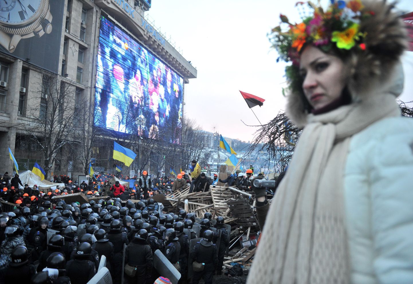 Rahvuslikke riideid kandev ukrainlanna vaatab pealt märulimiilitsate ja meeleavaldajate vastasseisu Kiievis Iseseisvuse väljakul.