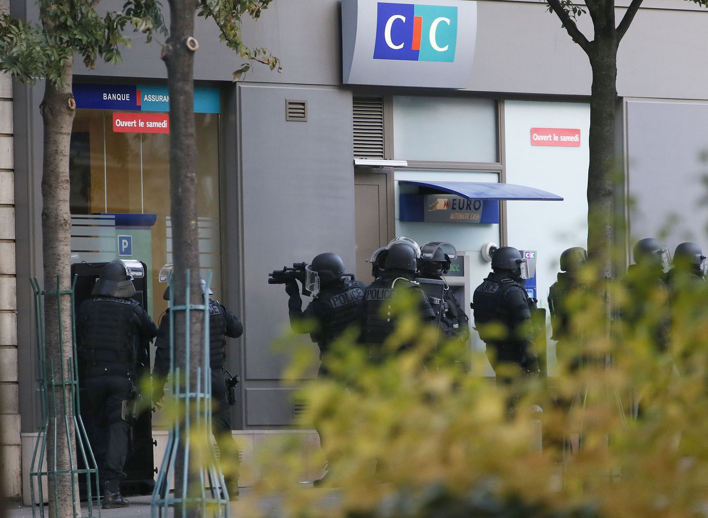 French policemen of the "Force d'intervention de la Police Nationale" (FIPN) stand outside a CIC bank while an armed man holds two people hostage inside in Paris on October 18, 2013. The man entered the branch of CIC bank in Paris's 13th district around 1450 GMT with a handgun and was demanding social housing for himself and his son, a police source said. AF PHOTO / PATRICK KOVARIK