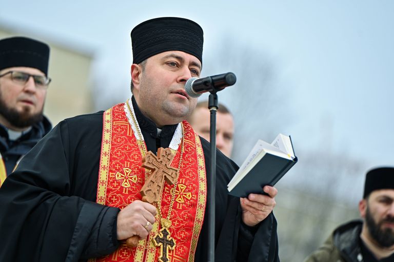 Отец Тарас Михальчук читает поминальную молитву на военном кладбище во Львове. Декабрь 2023. 