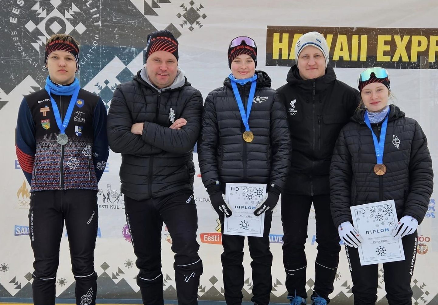 На пьедестале лыжного стадиона в Хаанья: завоевавший серебро в гонке с общего старта Андриас Ряэст, тренер Тимо Юурсалу, ставшая чемпионкой Анетте Аху, тренер Аво Самбла и занявшая третье место Херта Раяс.