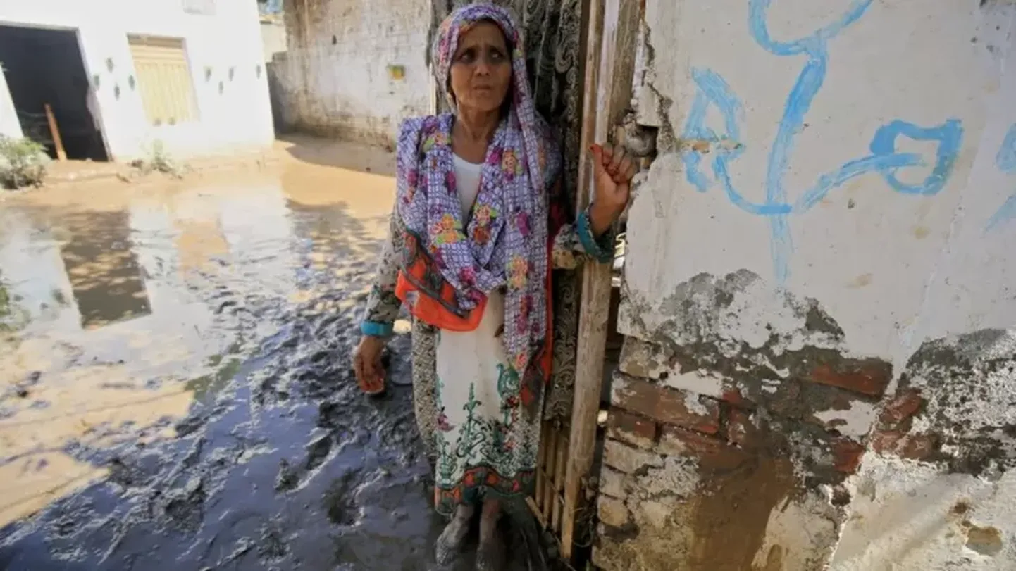 Женщина стоит возле своего дома в районе Чарсадда, провинция Хайбер-Пахтунхва, 28 августа 2022 года