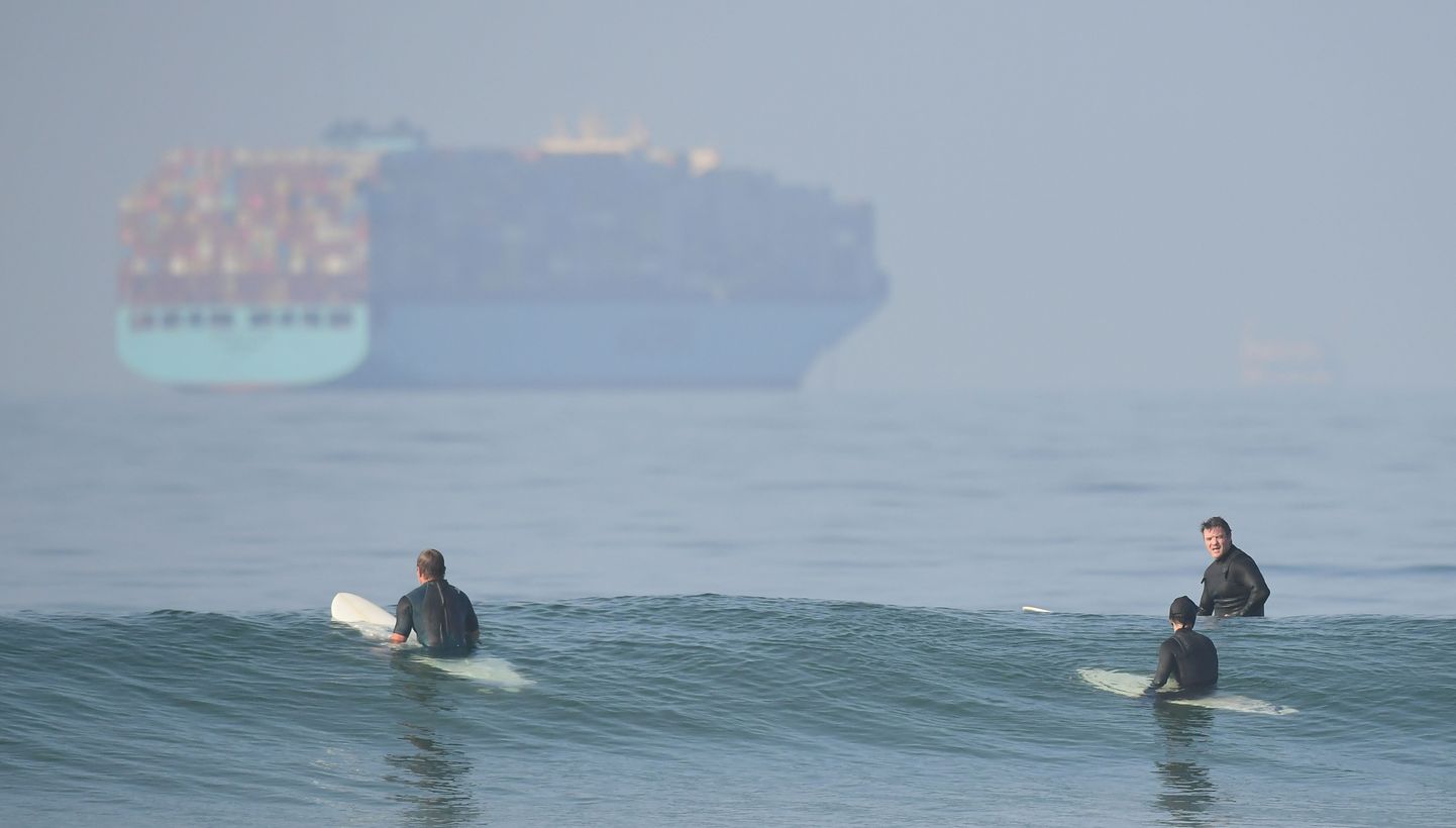 Surfajad Huntington Beach'l Californias. Reidil ootavad konteinerilaevad pääsu Los Angeles'i ja Long Beach'i sadamatesse. (Photo by Frederic J. BROWN / AFP)