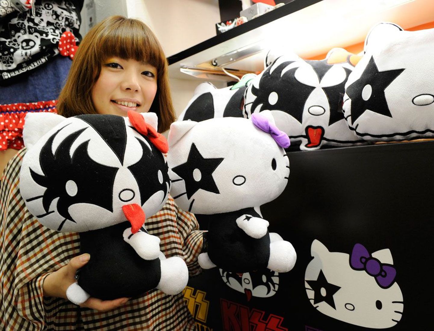 Sanrio töötaja demonstreerib firma peakorteris Tokyos USA glämmrokibändi Kiss temaatilisi Hello Kitty nukke.