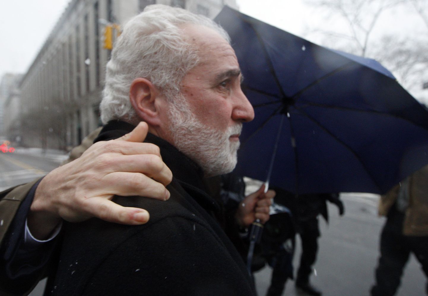 Daniel Bonventre 25.veebruaril New Yorgi föderaalkohtust lahkumas. Mees püüab fotograafide eemaletõrjumiseks kasutada nii advokaati kui vihmavarju.