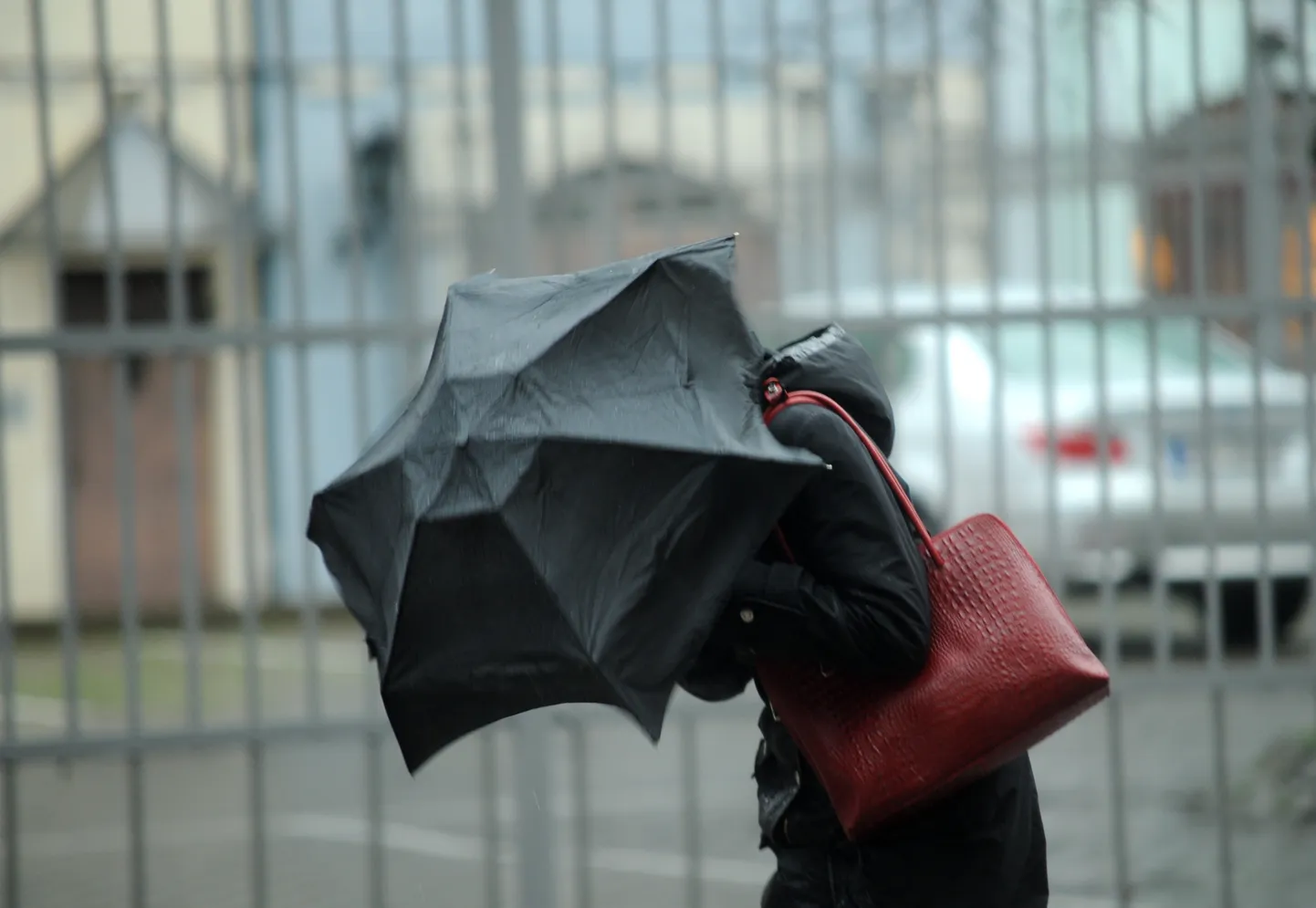 Sieviete ar lietussargu lietus un krusas laikā pilsētā.