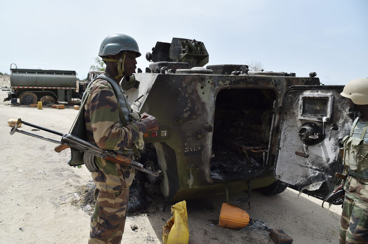 Nigeeria sõdurid põlenud soomusmasina kõrval.