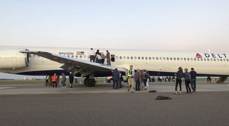 Reisijad väljuvad suitsuga täitunud lennukist tiiba pidi