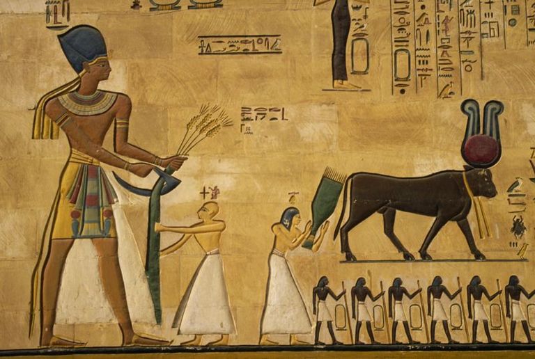 Фараон в военной синей короне. Тут он, правда, собирает урожай, но в руках все-таки хорошо режущий предмет. Военную корону можно было носить когда угодно
