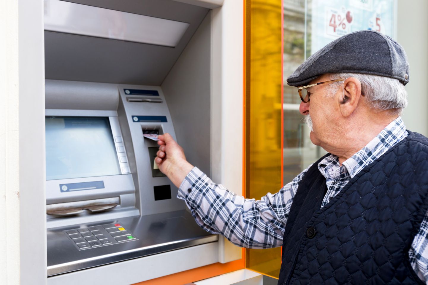 Пожилой человек возле банкомата.