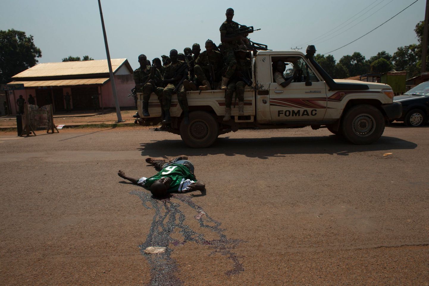 KAVi pealinn Bangui 20. detsembril. Tšaadi rahuvalvajad sõidavad mööda varem Kongo rahuvalvajaid väidetavalt rünnanud ja nende poolt tapetud mehe surnukehast.