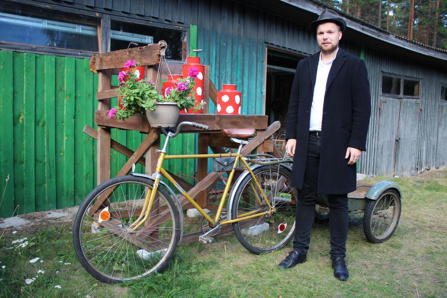 Andreas Piibemann Juhani jalgratta- ja koduloomuuseumi ees. Jalgratas mehe kõrval on 1987. aastal Valgevenes toodetud Aist.