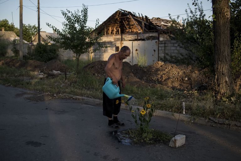 Mees kastab lilli sõjast purustatud Spartaki külas Donetski oblastis. Külas ja selle lähedal pidasid Ukraina valitsusväed ja valitsusvastased 2014. aastal mitu ägedat lahingut Donetski lennujaama pärast.
