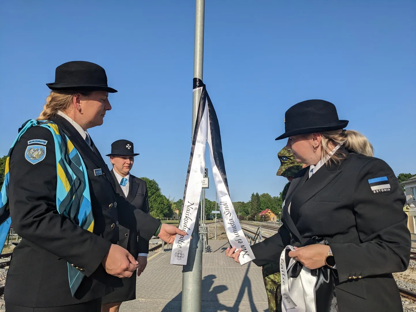 Naiskodukaitsjad sidumas leinalinte Käru raudteejaamas.