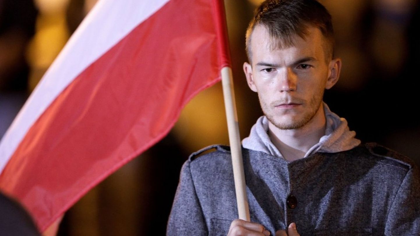 Мужчина, держащий флаг Польши