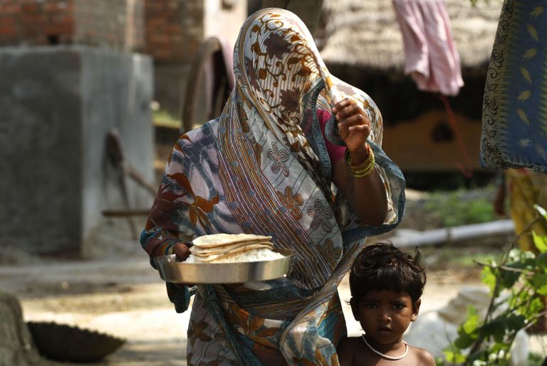 India külanaine pojaga viib põllule töölistele süüa. Foto: AP