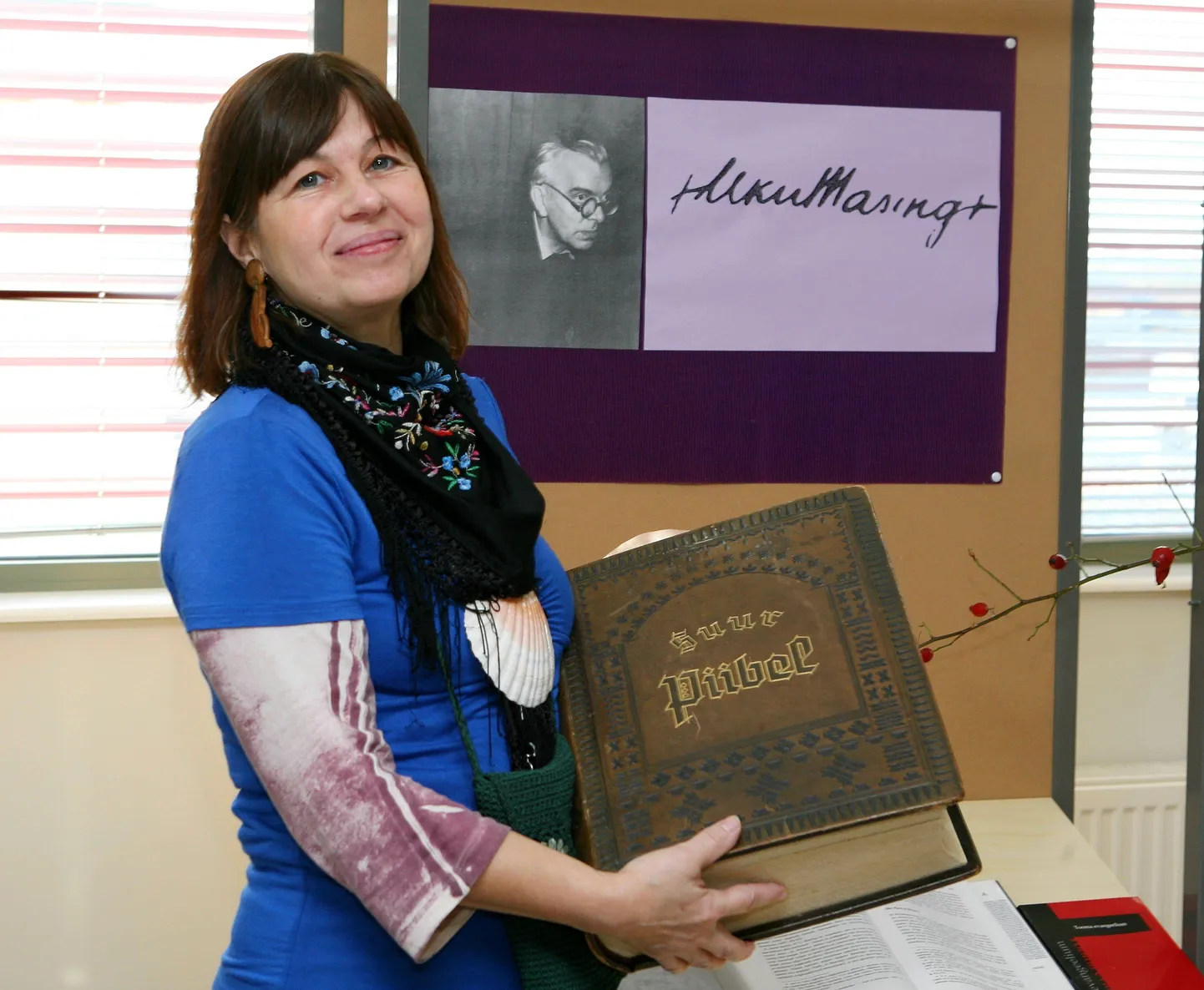 Näituse koostaja, bibliograaf Kalli Kuhi koos näituse kõige suurema teosega.