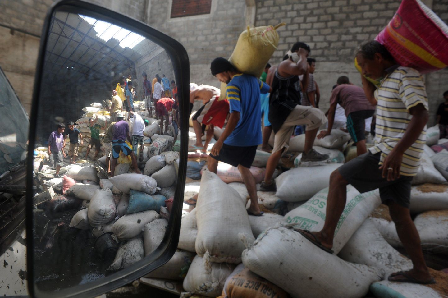Kohalikud röövivad Taclobani lähistel asuvast toidulaost riisikotte.