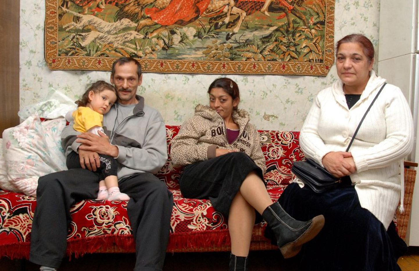 Pildil hoiab August Burkevitš oma Valga korteris süles lapselast Kajanat, tema kõrval istuvad Augusti õde Svetlana ja Lõuna-Eesti romade eestkõneleja Maila Grohovskaja.