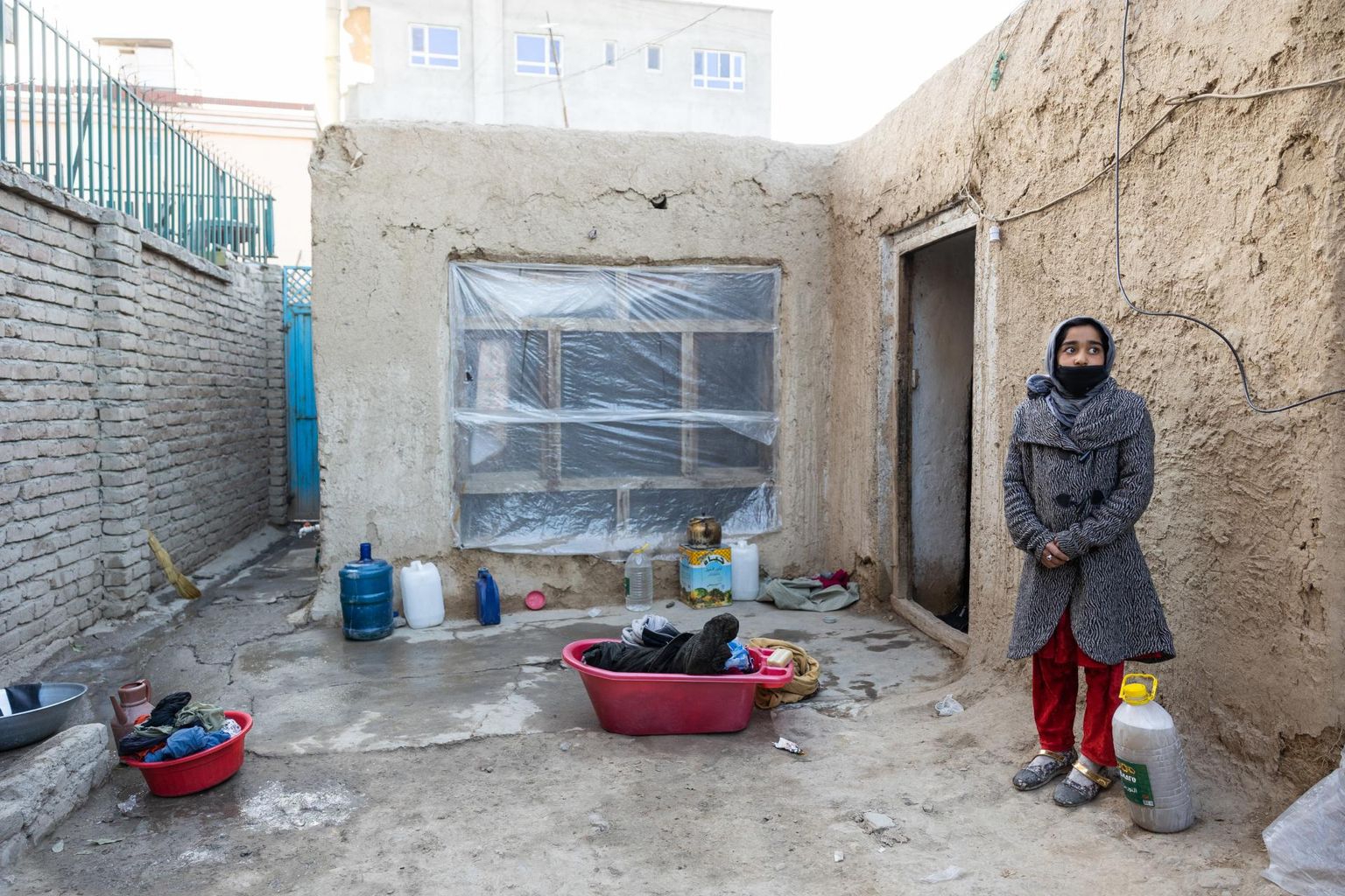 The family of Abdul, who used to work as a policeman for the previous government, lives in a bunker-like house the windows of which are covered in plast. Standing to the right is his 11-year-old daughter.