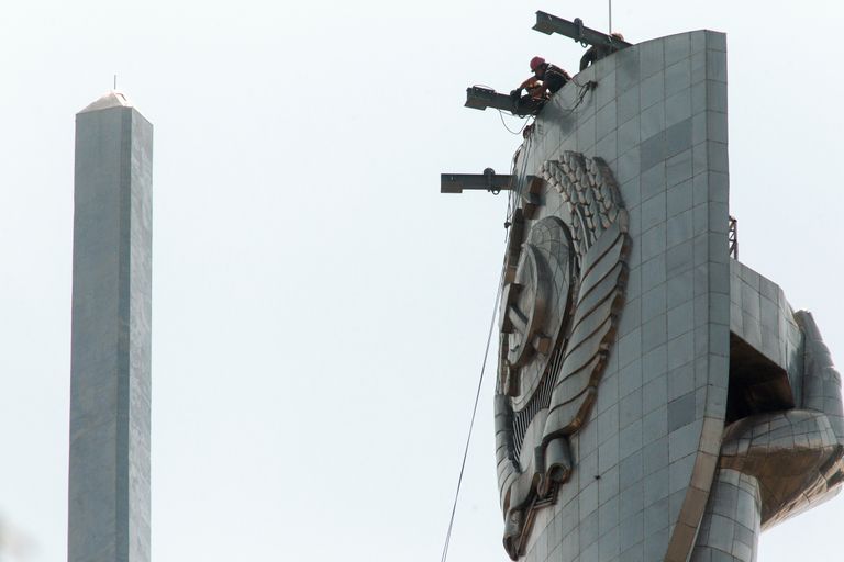 Рабочие готовятся к демонтажу герба Советского Союза со щита монумента «Родина-мать», который будет заменен гербом Украины. 24 июля 2023 года.