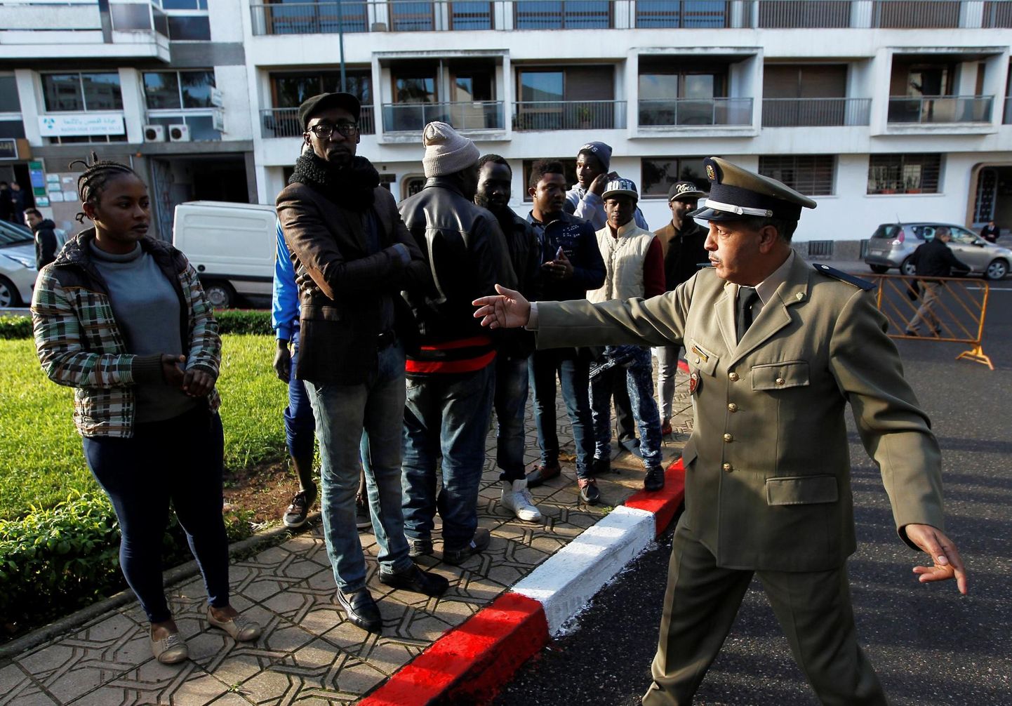 Maroko politseinik vestlemas Rabatis aafriklastest migrantidega, kes ootavad järjekorras, et saada luba riigis viibimiseks.