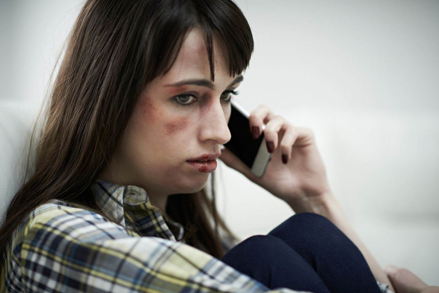 Vigastustega naine räägib telefoniga.