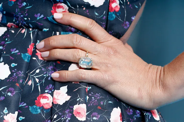 US actress Jennifer Aniston wears her diamond engagement ring as she poses upon arrival to attend the European premiere of the film 'We're The Millers' in London on August 14, 2013. AFP PHOTO / ANDREW COWIE