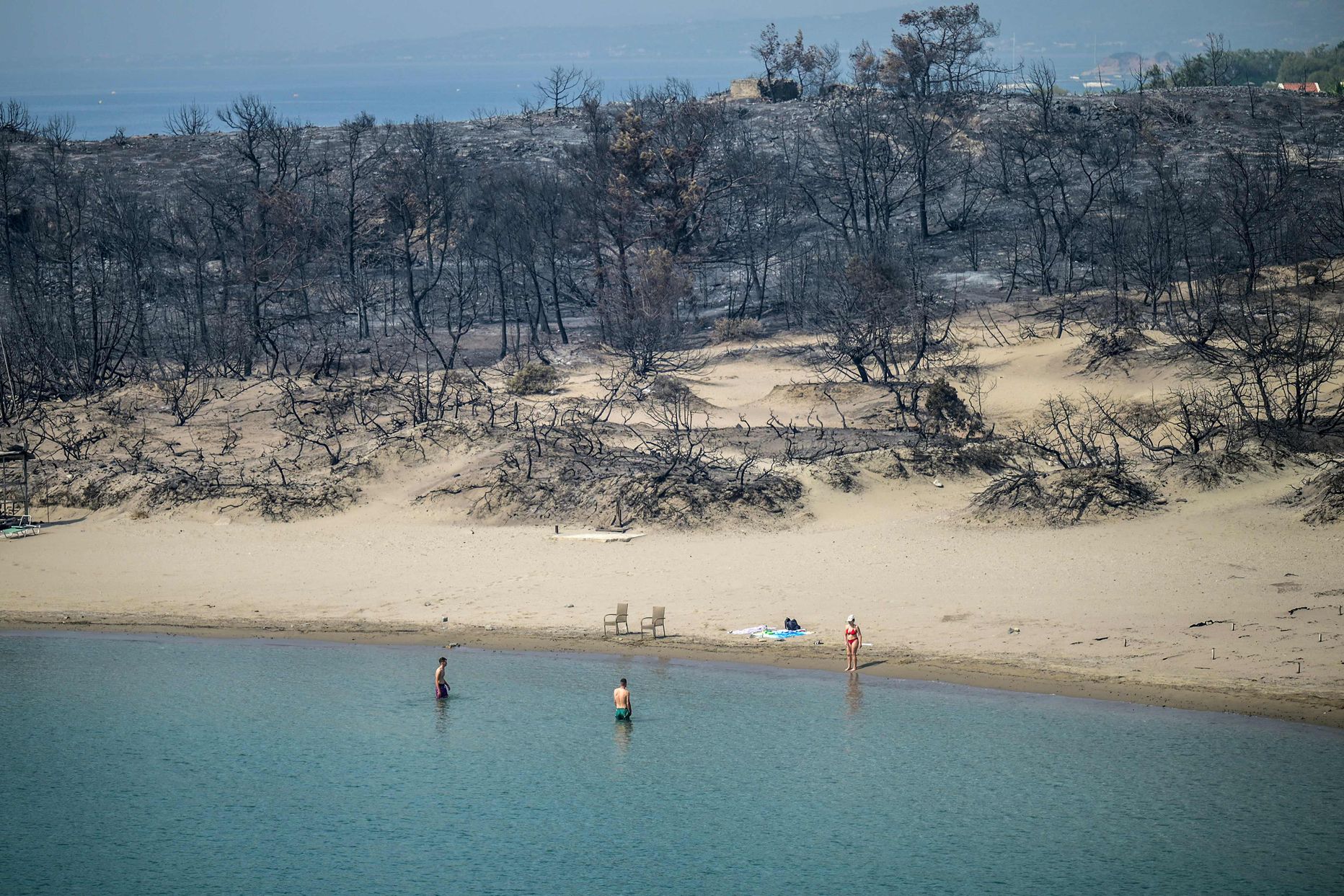 Inimesed ujuvad pärast maastikupõlengut Kreekas Rhodose saare rannikul