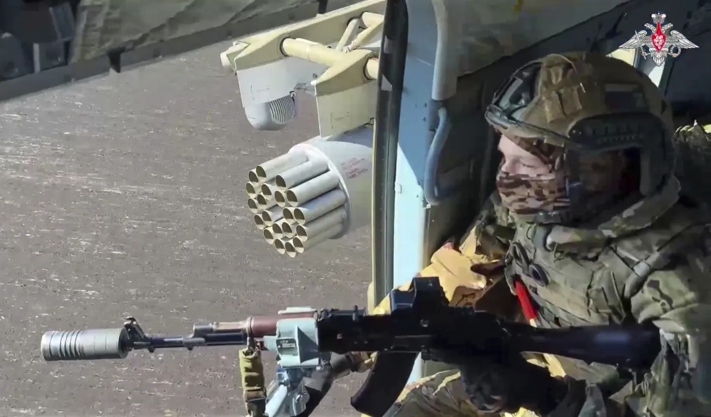 Krievijas armijas karavīrs kontrolē teritoriju no militārā helikoptera neidentificējamā vietā Ukrainā. Kadrs no Krievijas Aizsardzības ministrijas 2025. gada 19. maijā izplatīta videoieraksta