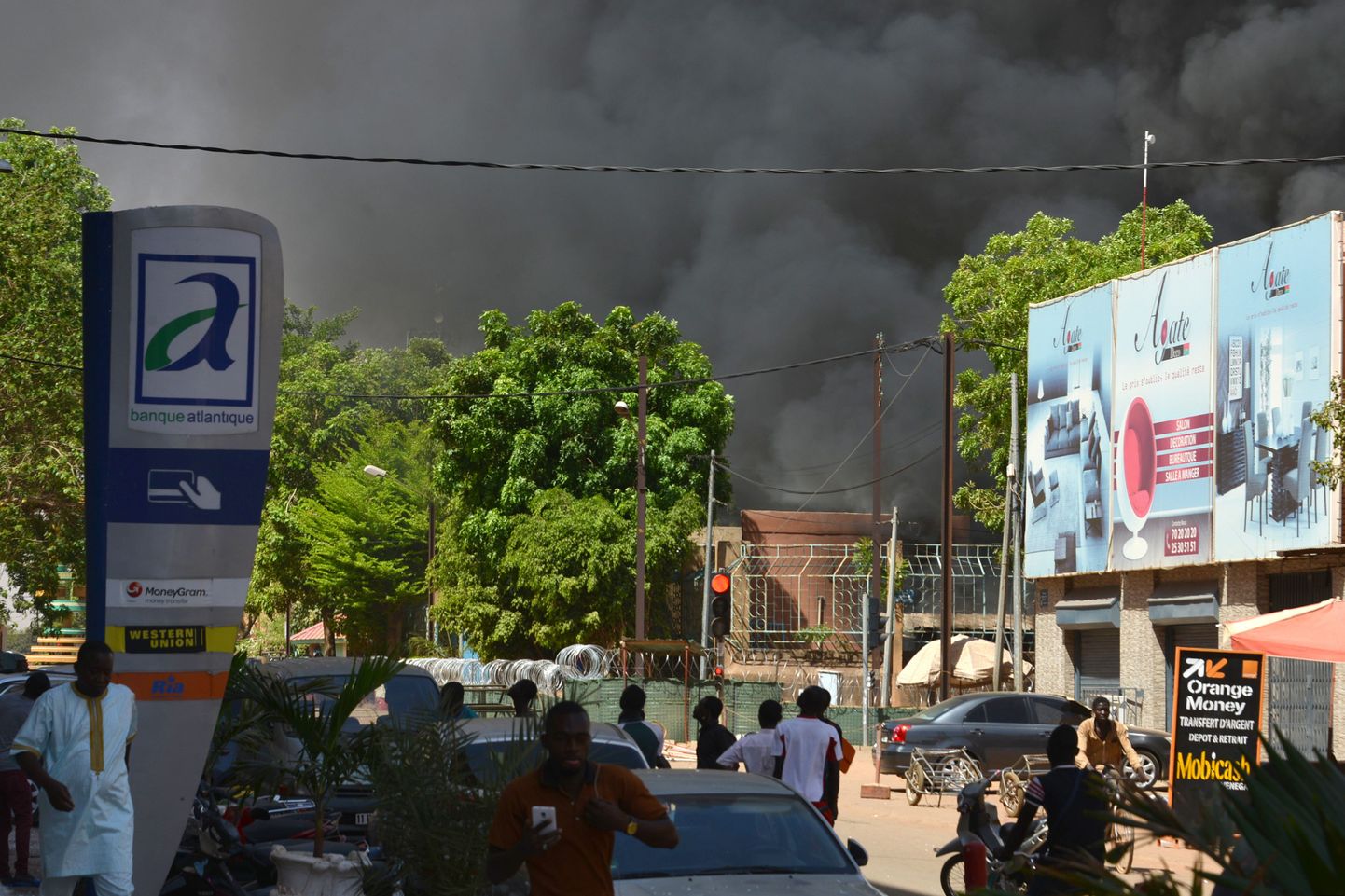 Inimesed vaatavad, kuidas Burkina Faso pealinnas käiv rünnak on tekitanud Ouagadougou kesklinna kohale suitsupilve.