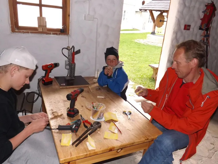 В комнате мастеров мы встретили туристов из Финляндии. Пока мама рассматривала экспонаты музея, папа с сыновьями увлеклись изготовлением самолетиков из дерева. Фото: