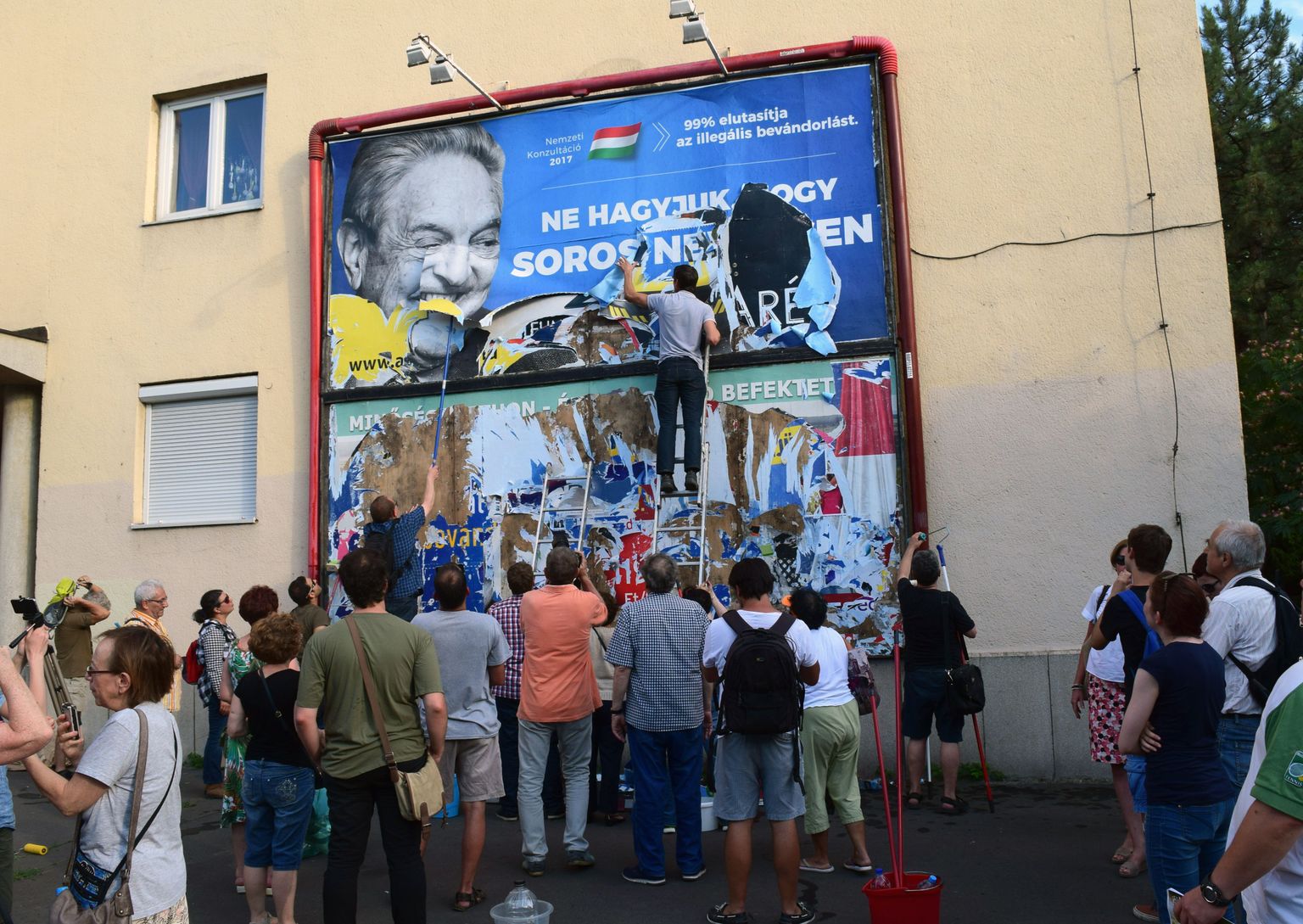 Aktivistid rebivad Budapestis maha George Sorosi vastast reklaamplakatit.