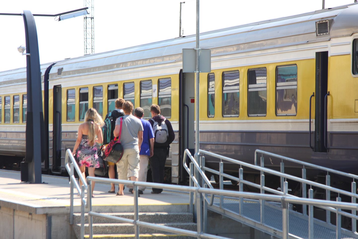 Valga-Riia reisirong. Reisijad lähevad rongi peale. Raudtee