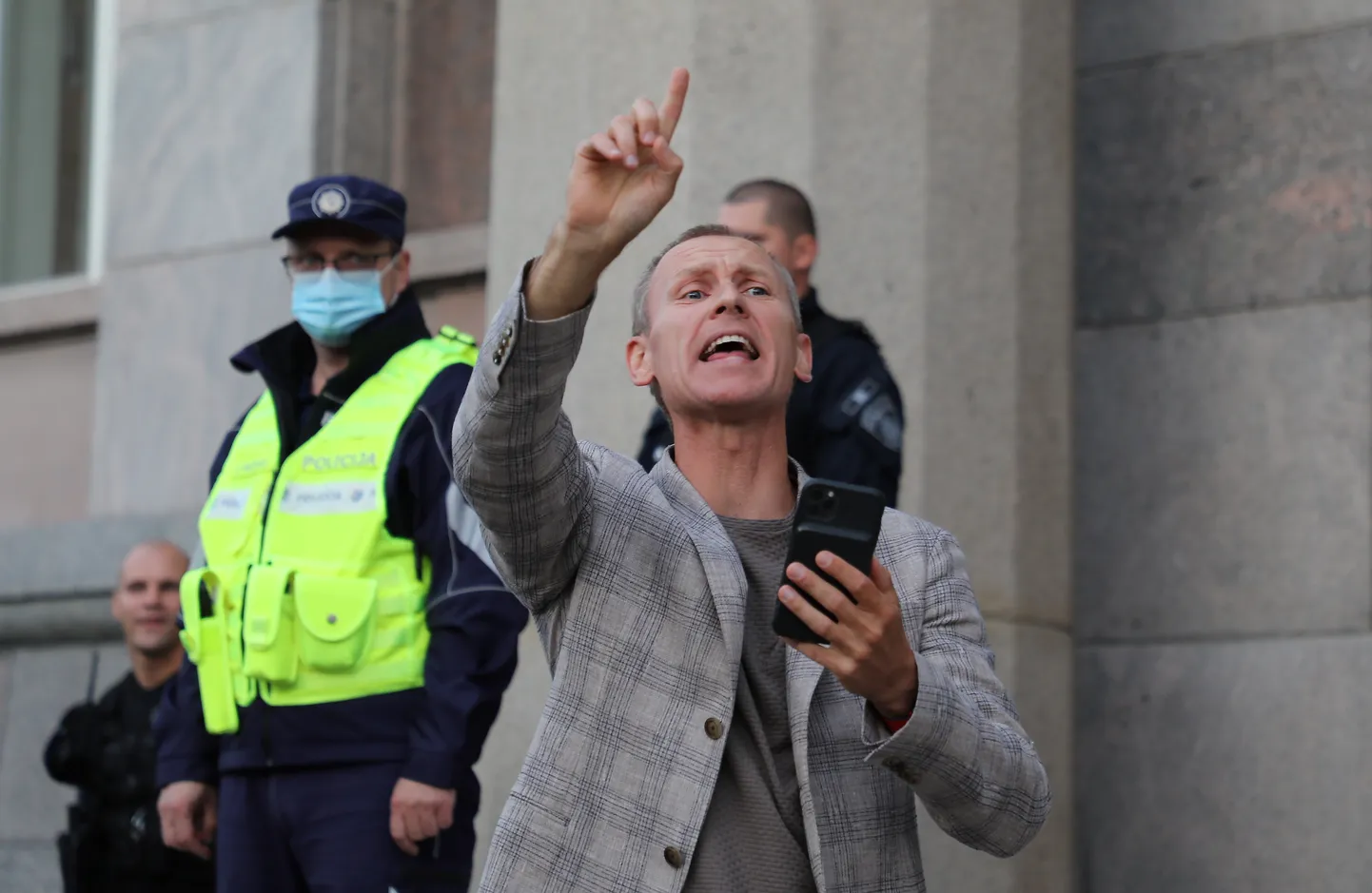 Saeimas deputāts Aldis Gobzems pie Ministru kabineta ēkas, kur norisinās protests pret Saeimā konceptuāli atbalstīto likumprojektu par tiesībām atlaist darbiniekus bez Covid-19 sertifikāta.