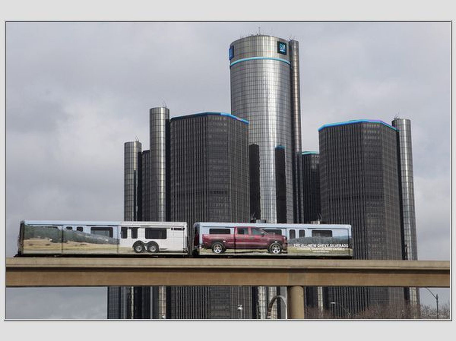 2014. aasta Chevy Silverado reklaamiga reisivagunid General Motorsi peakorteri taustal Detroidis.