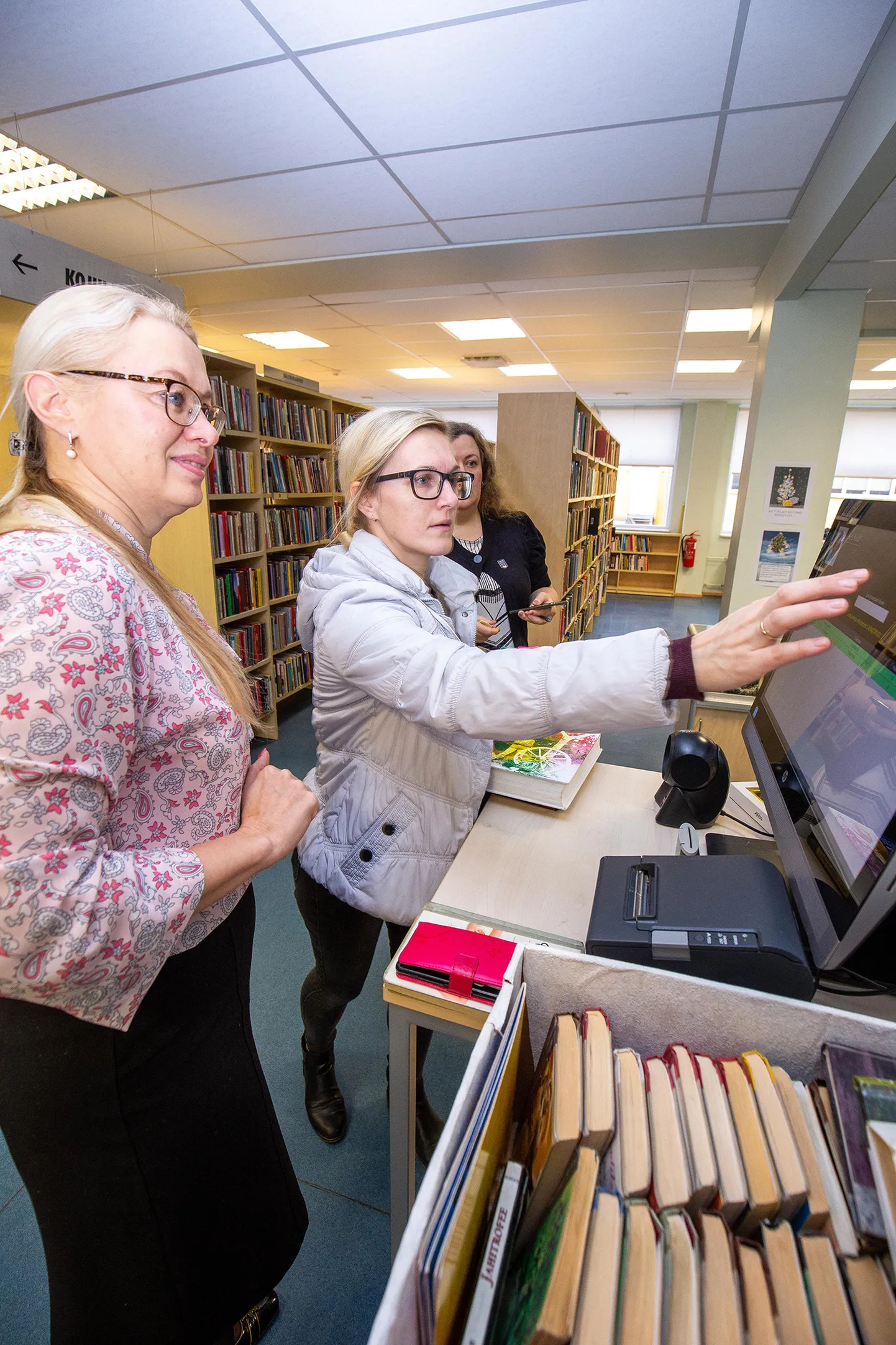 Jane Kiristaja (vasakul) näitab Kaidi Assinile, kuidas uus iseteenindussüsteem töötab.