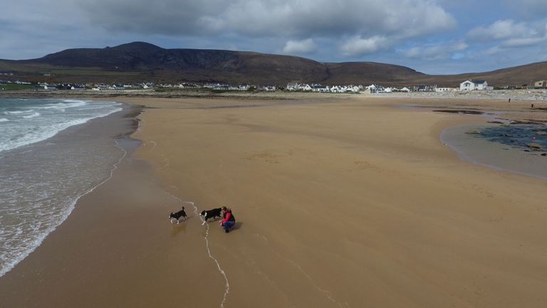 Naine oma koertega Achilli saare rannal / Handout/Reuters/Scanpix