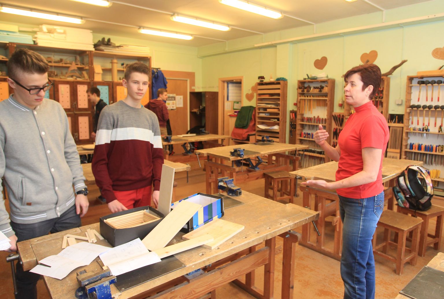 Raatuse kooli õpetaja Tiiu Laid seisab oma klassis koos üheksandike Art Ross Ausi ja Kristofer Parvega, kes peavad kooliaasta lõpuks ehitama väikse palkmaja.