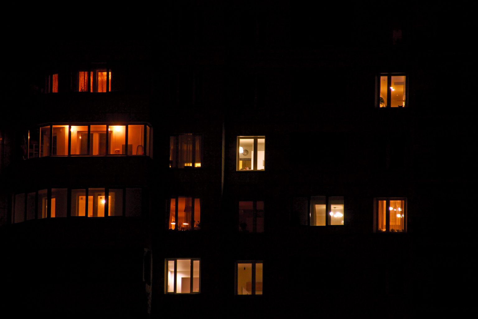 Daudzdzīvokļu nams tumsā.