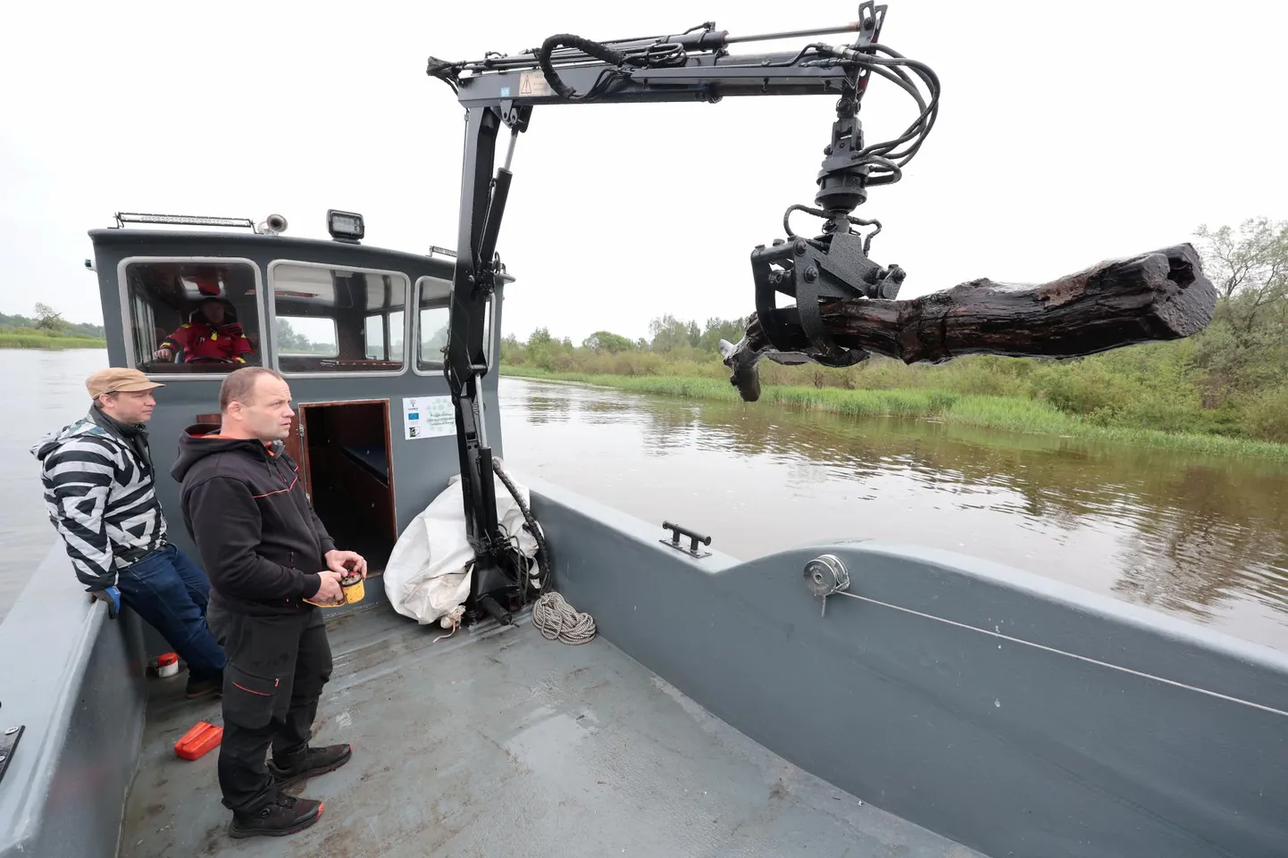 Prügilaevaga saab jõest välja tõmmata ka suuri puuronte, ent see pole voolu tõttu sugugi lihtne, rääkis kraanat juhtinud Margus Rohtmets (esiplaanil), kelle tööd jälgis kõrvalt TOLi projektijuht Egert Ivask.