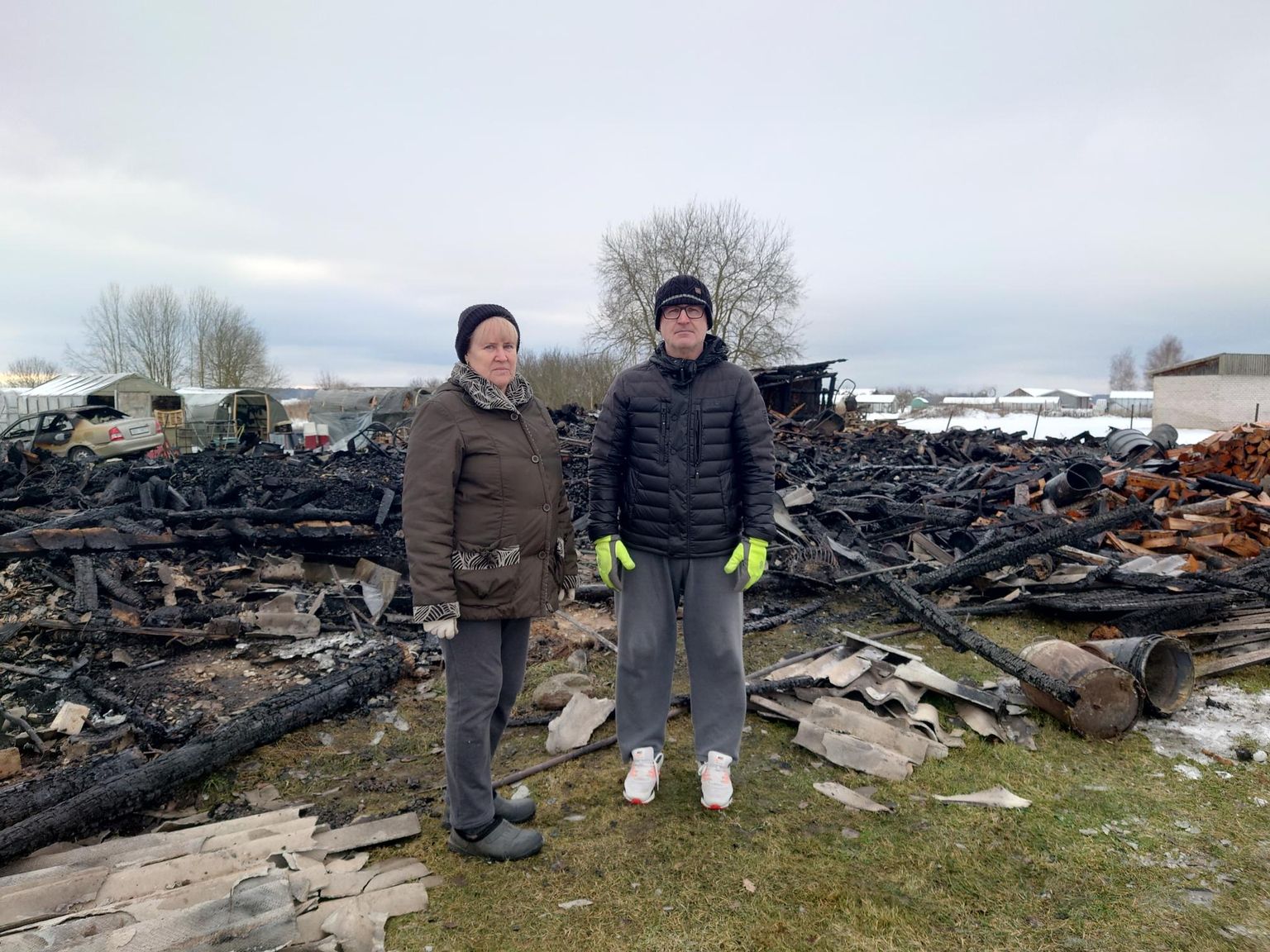 Kortermaja elanikud Rita Mustonen ja Andrei Kotov põlenud puukuurist suurt midagi kütteväärtuslikku enam ei leidnud.