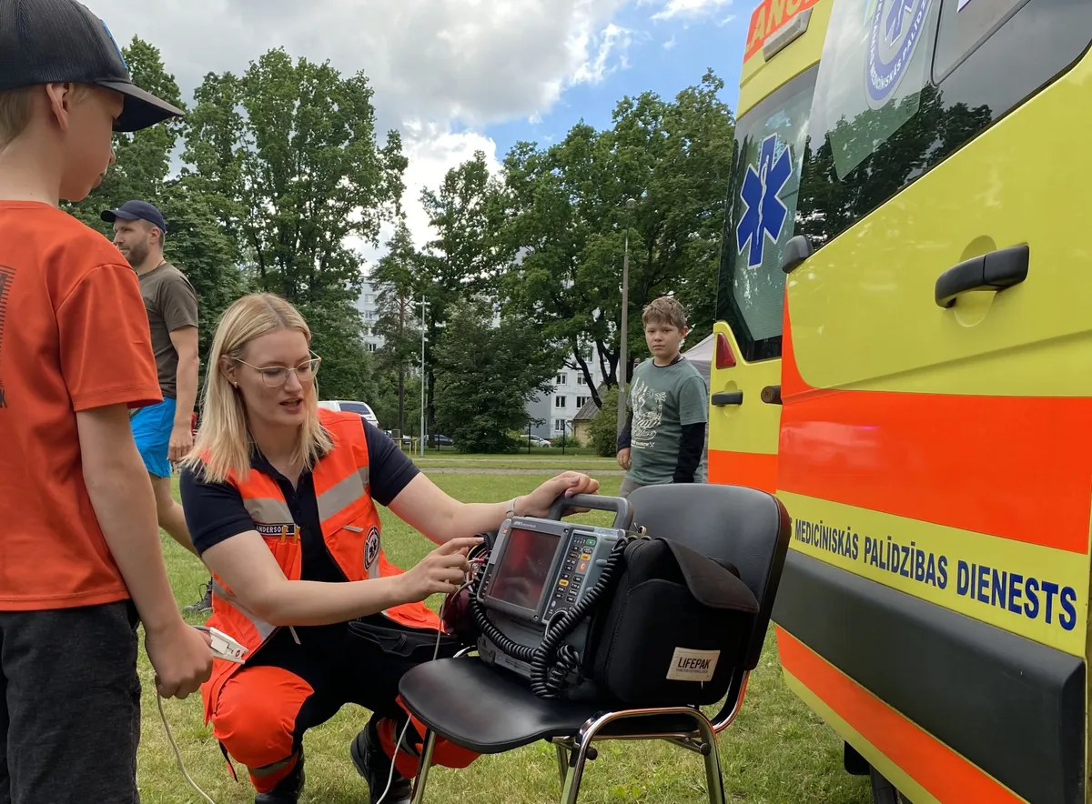 15 June 2024, Latvia, Jurmala: A paramedic explains how a medical device works to visitors at the nationwide Civil Protection Information Day.