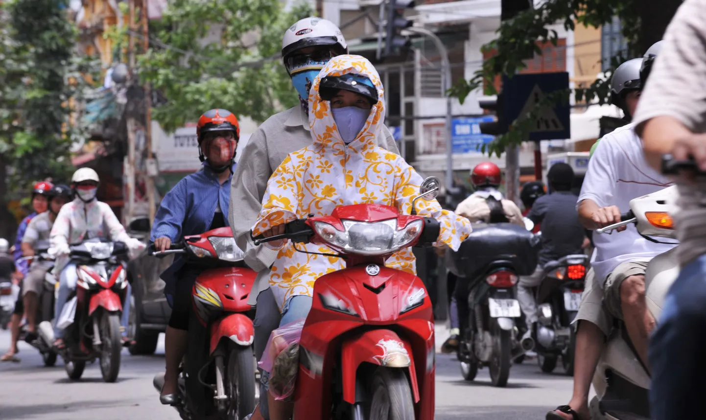 Vietnamlased kaitsevad end kuuma päikese eest maskide ja pikavarrukaga pluusidega.