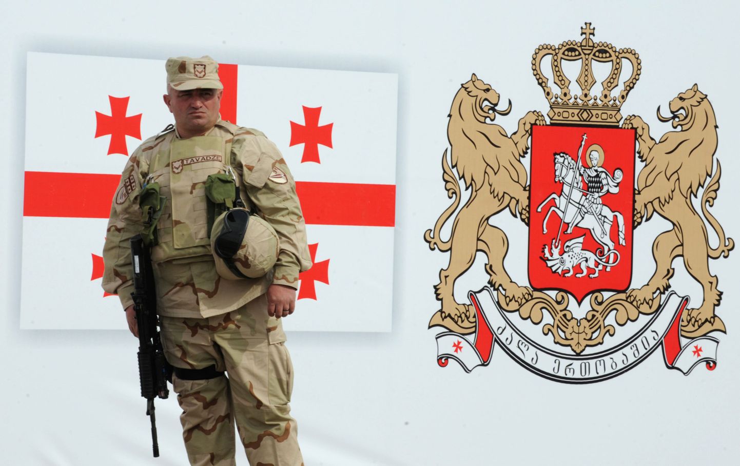Gruusia sõdur seisab plakati ees, millel on kujutatud riigilipu ja vappi. Pilt on tehtud Thbilisi lähistel asuvas Vaziani baasis enne väljalendu Afganistani.